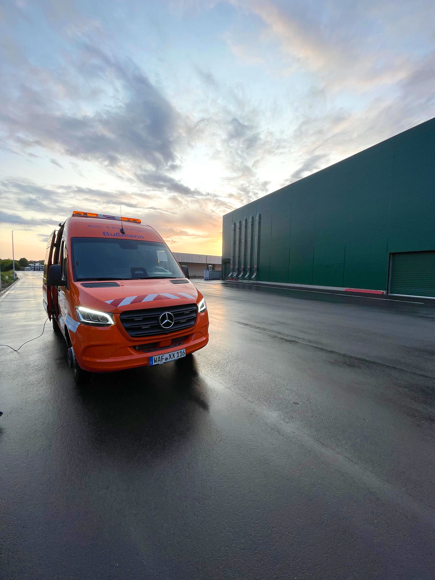 Bußmann Rohr und Kanalreinigung Firmenwagen auf Parkplatz vor idyllischem Sonnenuntergang